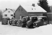 Mölndals Bud-transport. Ett antal lastbilar uppställda på gården. Rundbergsgatan, 1960-tal.
