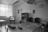 Dokumentation av Sagåsens flyktingförläggning 1992. Ett möblerat allrum med tv, bokskåp och spel som ligger på ett bord.
