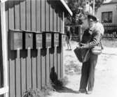 Post lägges i lådorna på Hanö. Alla lådorna är placerade i hamnen.
Foto i augusti 1959.