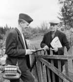 Per Jönsson, Rävapellen, i Kärraboda får dagens post. Vikarierande bilåkande lantbrevbäraren Gert Stjernqvist, på linjen Lönsboda-Duvhult. 

Foton maj 1961.