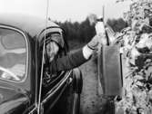 Bilkåkande lantbrevbäraren Cyril Falk på linjen Lönsboda-Hunshult-Björkhult-Lönsboda.  Foton maj 1961. En brevlåda i Tomaboda får post.