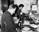 Lantbrevbärare Ruben Carlsson hämtar paket och postförskott hos stationsmästaren fru Henriksson, Täby, före brevbäringsturen.