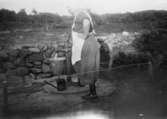 Elisabeth Andersson pumpar upp vatten för hushållsbruk, 1935.