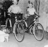 Ulf och Marita Jerkeskog poserar med sina nya cyklar, julen 1960. En julgran skymtar i bakgrunden.