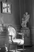 Dokumentationsbilder från Gunnebo slott våren 1992. Inredningsmiljö, konstföremål och möbler av varierande slag. Här ses en stol och en skulptur ståendes vid en vägg.