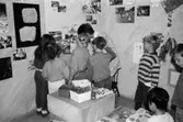Några barn och en vuxen tittar på foton som sitter uppsatta på en vägg. Utställningsvernissage av och om Katrinebergs daghem på Mölndals museum 1993-09-10.