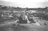 Astrid Garthman och Arne Jansson sitter på en klippa vid Smittska udden i Näset, 1950-tal.
