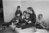 Kajsa Lindgren läser en saga för barnen Rikard, Sofia, Jessika, Martin och Rick. Samtliga sitter på en madrass. Lunkentussen, Katrinebergs daghem 1992-93.
