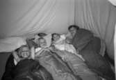 Birgitta Fält med barnen Jessika, Sofia och Andreas ligger i sovsäckar inne i ett tält. De kommer från Lunkentussen, Katrinebergs daghem, 1992-93.