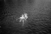 En kvinna och ett barn, på utflykt med Katrinebergs daghem, simmar omkring på djupt vatten. Kvinnan håller i barnet.