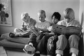 Jimmie, Pontus, Erik och Robin sitter tillsammans i en säng och läser böcker. På väggen vid sidan om sängen, hänger en tavla med ett tecknat troll. Hoppetossan, Katrinebergs daghem 1992.