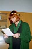 Museichef Mari-Louise Olsson läser på ett papper. Detta i samband med avtackning av receptionist Kim Linder på Mölndals museum 1994.