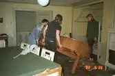 Tre män som monterar ihop en nyligen förflyttad flygel. Gunnebo slott, 1988.