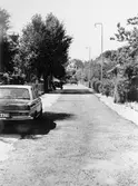 Man ser den del av Barnhemsgatan, som går mellan Storgatan och Holtermansgatan, år 1975. Till vänster står en Mercedes Benz parkerad på gatan.