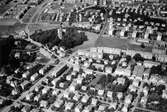 Flygfoto taget 1962 över Broslätt, Mölndalsbro och Fässbergs kyrka. Man ser delar av Broslättsgatan, Frölundagatan och Tempelgatan samt Storgatan, Villagatan och Nygatan. I bakgrunden ses Bosgården och Toltorp. Längst upp till vänster ses lägenheterna på Lerbrännargatan.