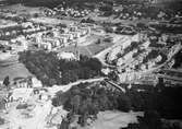 Flygbild över delar av Mölndals centrum och Bosgården, ca 1960-67. Man ser området kring Fässbergs kyrka, Växthusgatan, Knarrhögsgatan, Tempelgatan, Bergmansgatan och Frölundagatan.