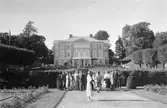 En grupp människor står i parkens trappa på Gunnebo slotts norra sida, 1930-tal.