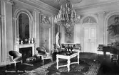 Gunnebo slott, 1930-tal. Stora salen här möblerad med kristallkrona, vackra möbler samt en flygel. I bakgrundens mitt ses gipsfiguren 