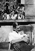 Greve Ultz von Kanitz (make till Ursula von Eckstädt) sitter i en solstol och håller ett spädbarn i famnen. Pommerwitz i Övre Schlesien, 1930-tal. (Foto från Hilda Sparre, Gunnebo)