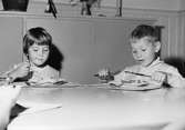 Två barn som äter mat på Holtermanska daghemmet 1953.