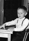 En pojke sittandes vid ett bord och leker med pussel. Holtermanska daghemmet 1953.