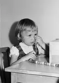 Flickan Marita Andersson, gift Björk, som trär kulor på en tråd. Holtermanska daghemmet 1953.