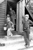 Tre barn och en fröken vid ett förrådshus. Holtermanska daghemmet 1973.