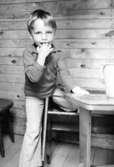 En pojke inne i ett förrådshus. Holtermanska daghemmet 1973.