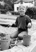 En pojke leker i sandlådan. Holtermanska daghemmet 1973.