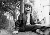Ett barn sitter i sandlådan. Holtermanska daghemmet juni 1974.