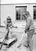 Två barn som gräver i sandlådan. Holtermanska daghemmet juni 1974.