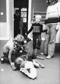 Barn som leker på golvet med en leksakskrokodil. Holtermanska daghemmet maj 1975.