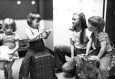 En fröken och tre barn som leker med kuddar.  Holtermanska daghemmet maj 1975.