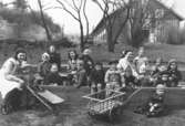 Fröknar och barn vid Holtermanska daghemmet våren 1947. I bakgrunden ses ladugården som hör till Åby Mellangården 3 (Pål-Emils). Ladugården låg söder om Holtermanska och boningshuset ligger norr om gatan.