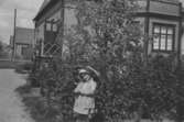 Lillemor Andersson (mor till givaren) framför huset på Barnhemsgatan 13, 1930-talets början.