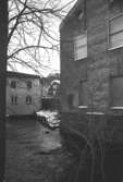 Kvarnfallet 31 i Grevedämmet, hösten 1994. Turbinhallen, G-5. Södra och östra fasaderna. Fabriksbyggnad i tegelsten vid vattendrag.