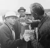 Bokhandlare Sigurd Tullberg lägger ned de 600 försändelser, som
skall skjutas iväg i raketens postbehållare.