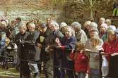 Kvarnbydagen 28 april 2002. Besökare står utanför Lilla Götafors i väntan på invigning av Royens spång. I mitten står Mölndals museums illustratör Lars Grehn (grått hår och glasögon).