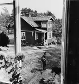 Intill Möja ligger Södermöja där Österman har sitt postområde.
Österman ses genom fönstret till sin bostad, som han passerar på väg
till sitt postområde.