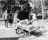 Posten har kommit till Ljusterö med transportören Fritjof Almgren.
Lantbrevbärare Stina Johansson och poststationsföreståndare fröken
Astrid Karlsson,Ljusterö (t.h.), möter upp.