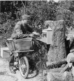 Postiljon Arnold Carlsson (Post-Kalle) tömmer brevlådan vid
Harrvägen-Rödstuguvägen-Kyttingevägen intill Lidingö golfbana.