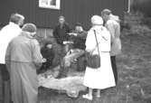 Familjesöndag vid Börjesgården, 1994-05-15. Personer står och ser på när en man visar hantverk.