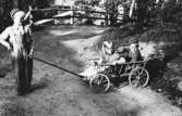 Eva Pettersson (gift Kempe) åker skrinda tillsammans med Christer Andersson i Torrekulla 1948. Göran Andersson drar skrindan. Barnen är lekkamrater och grannar.