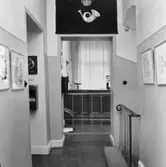 Passagen mellan rum 5 och 6. Till vänster trappa ned till 1:a
våningen. I bakgrunden 1910-års postkontor samt till höger öppning
mot rum 6.