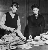 Dagens första post till Reklamationskontoret. Säckar öppnas,
värdepost dekarteras (ca 20 rekpaket om dagen). Birgit Lönnberg och
Rolf Eriksson hjälps åt.