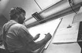 En man i arbete.
Bilden ingår i serie från produktion och interiör på pappersindustrin Papyrus, 1980-tal.