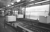 Interiör där pappersbalar går på löpande band i pappersfabriken.
Bilden ingår i serie från produktion och interiör på pappersindustrin Papyrus1980-tal.