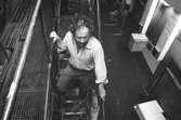 Juris Kuvalds på väg nedför en trappa i Byggnad 6, 1980-tal. 
Bilden ingår i serie från produktion och interiör på pappersindustrin Papyrus.