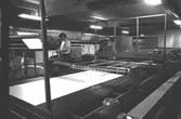 Roger Techel i arbete vid pappersmaskinerna, 1980-tal.
Bilden ingår i serie från produktion och interiör på pappersindustrin Papyrus.