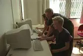 En lärare och två elever framför två datorer på Fässbergsgymnasiet, cirka 2002.